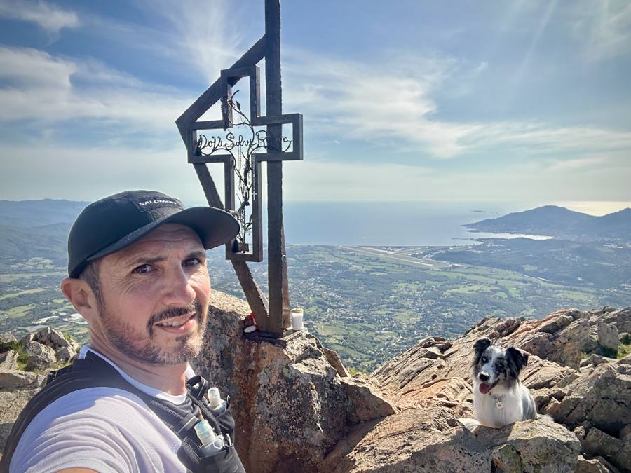 Emmanuel Cardi au sommet, près de la croix, son chien derrière lui